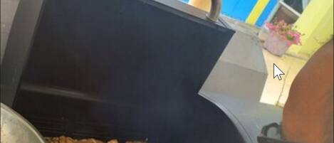 A person grilling meat on an outdoor grill.