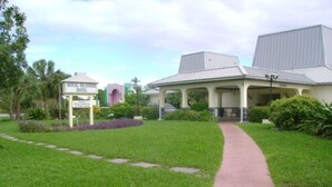 Ein Hotel mit überdachtem Gang, üppigem Rasen und einem Schild, das es als Royal Islander Hotel kennzeichnet.