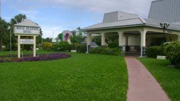 Le Royal Islander Hotel dispose d’un espace extérieur aménagé avec une zone de repos couverte, d’un chemin menant à l’entrée et d’un jardin paysager agrémenté de fleurs violettes.