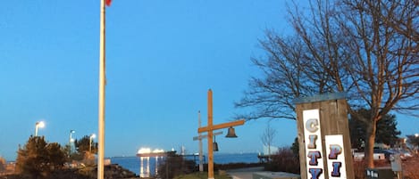 A park with a wooden bench, a signpost, and a flagpole.