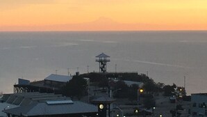 A coastal view with a clock tower, buildings, and a clear sky.