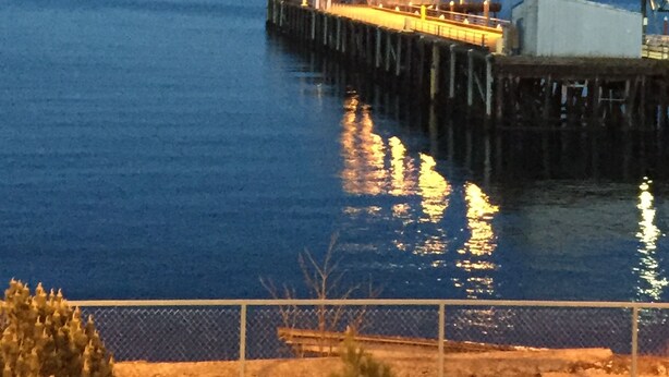 A pier extending into calm water with a small structure at the end. - Port Angeles Inn (Port Angeles)