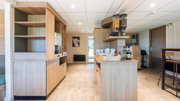 Una cocina moderna con muebles de madera, una isla central y una zona para café.