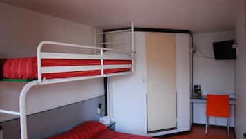 Ein Schlafraum mit Etagenbetten, einem Schreibtisch, einem Stuhl, einem Kleiderschrank und einem Fernseher.