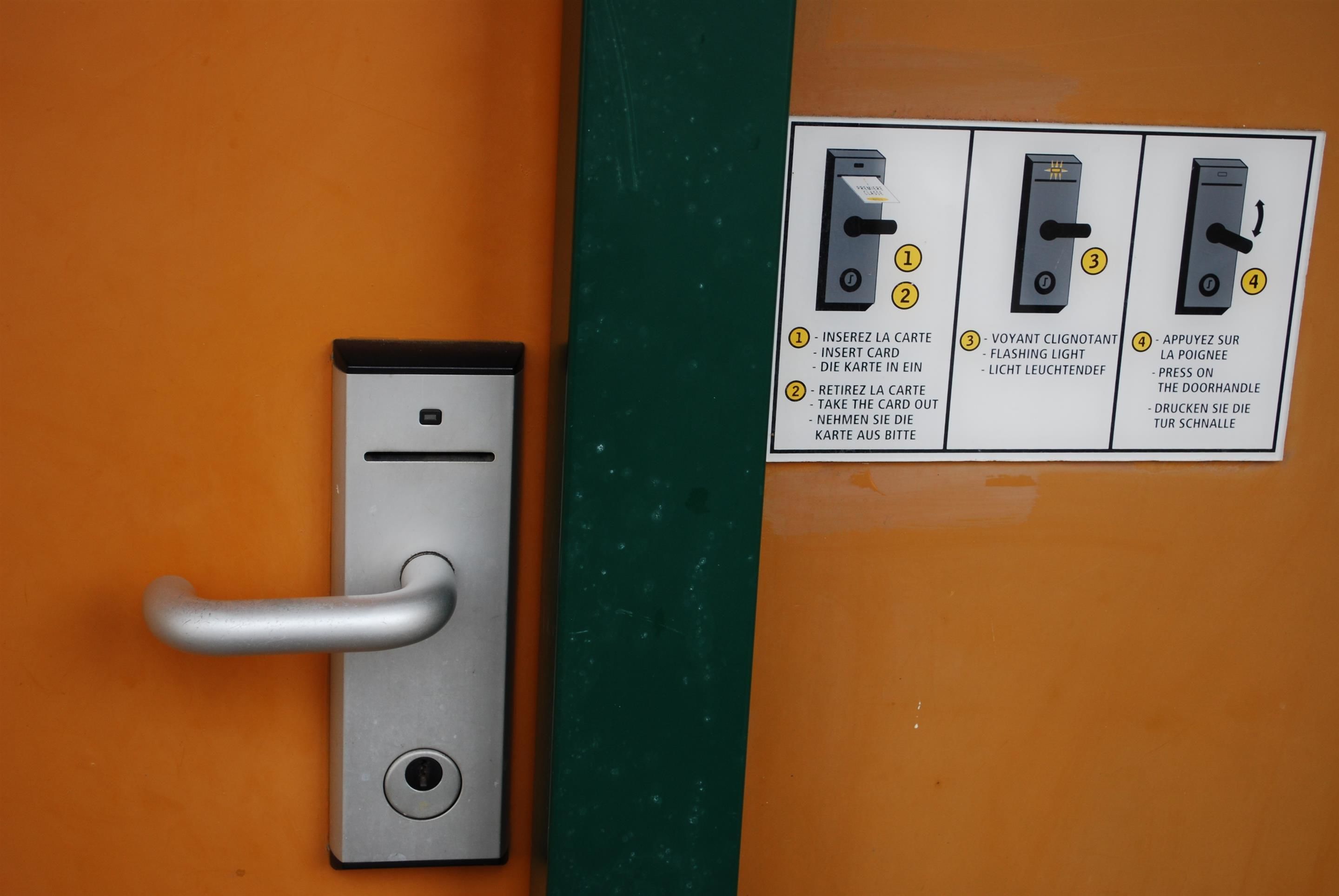 A door with a card reader and instructions for use.