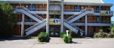 Un edificio con una escalera central, varios pisos y un cartel que indica un precio de 41€.