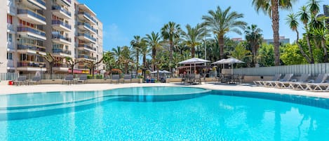 Una piscina al aire libre, tumbonas