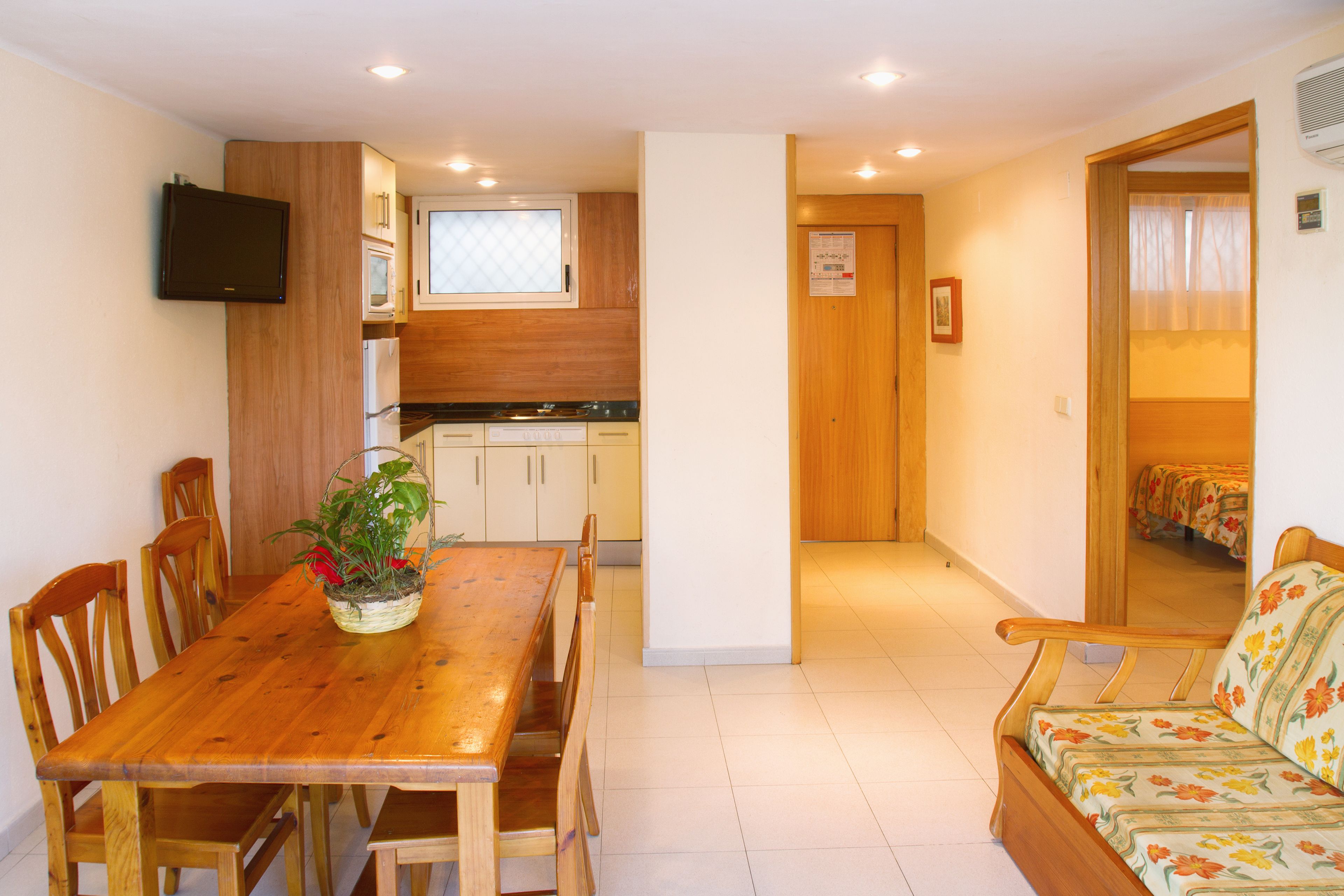 A compact living space with a dining area, kitchenette, and a sofa.