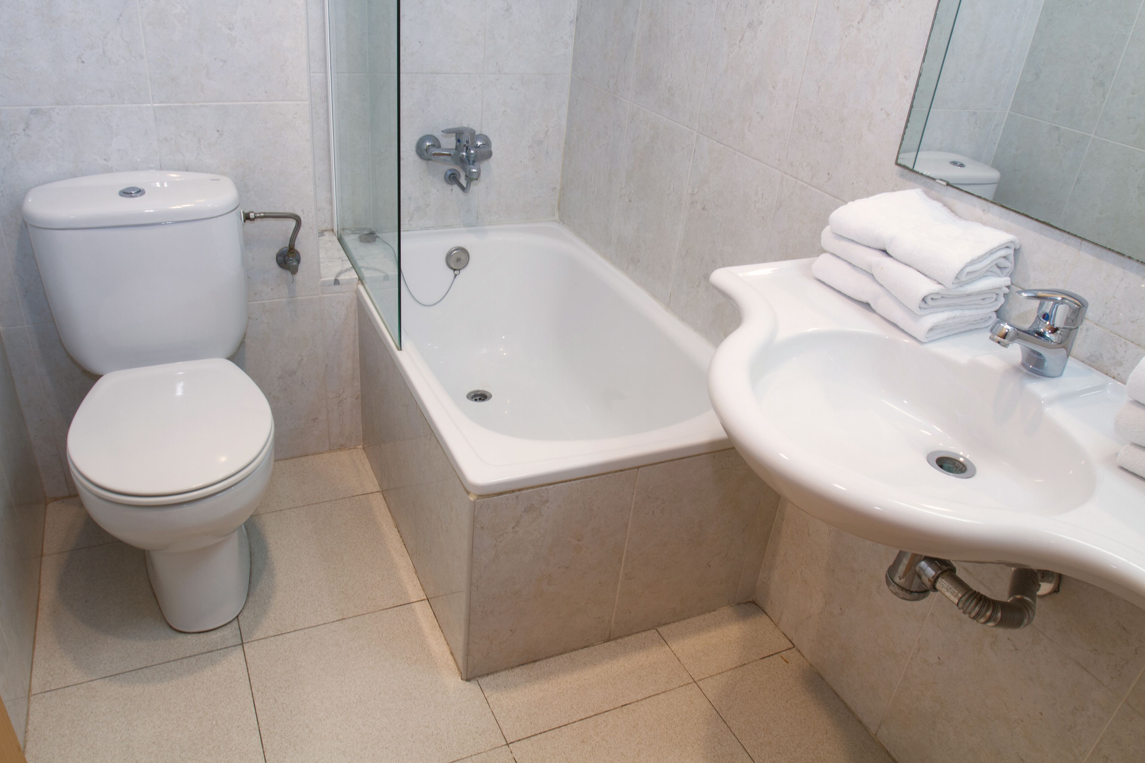 A bathroom with a toilet, bathtub, and sink.
