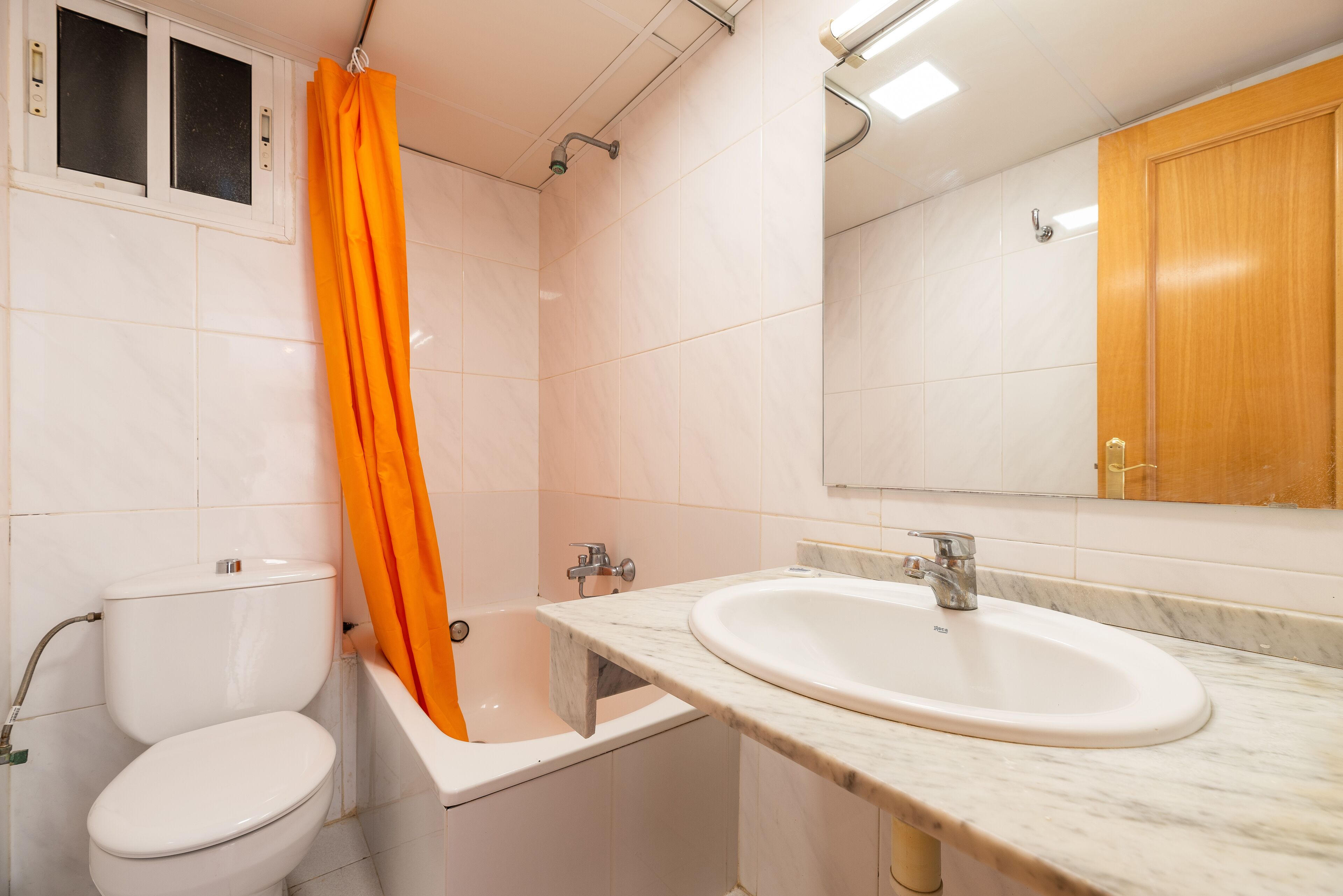 A bathroom with a toilet, bathtub, and sink.