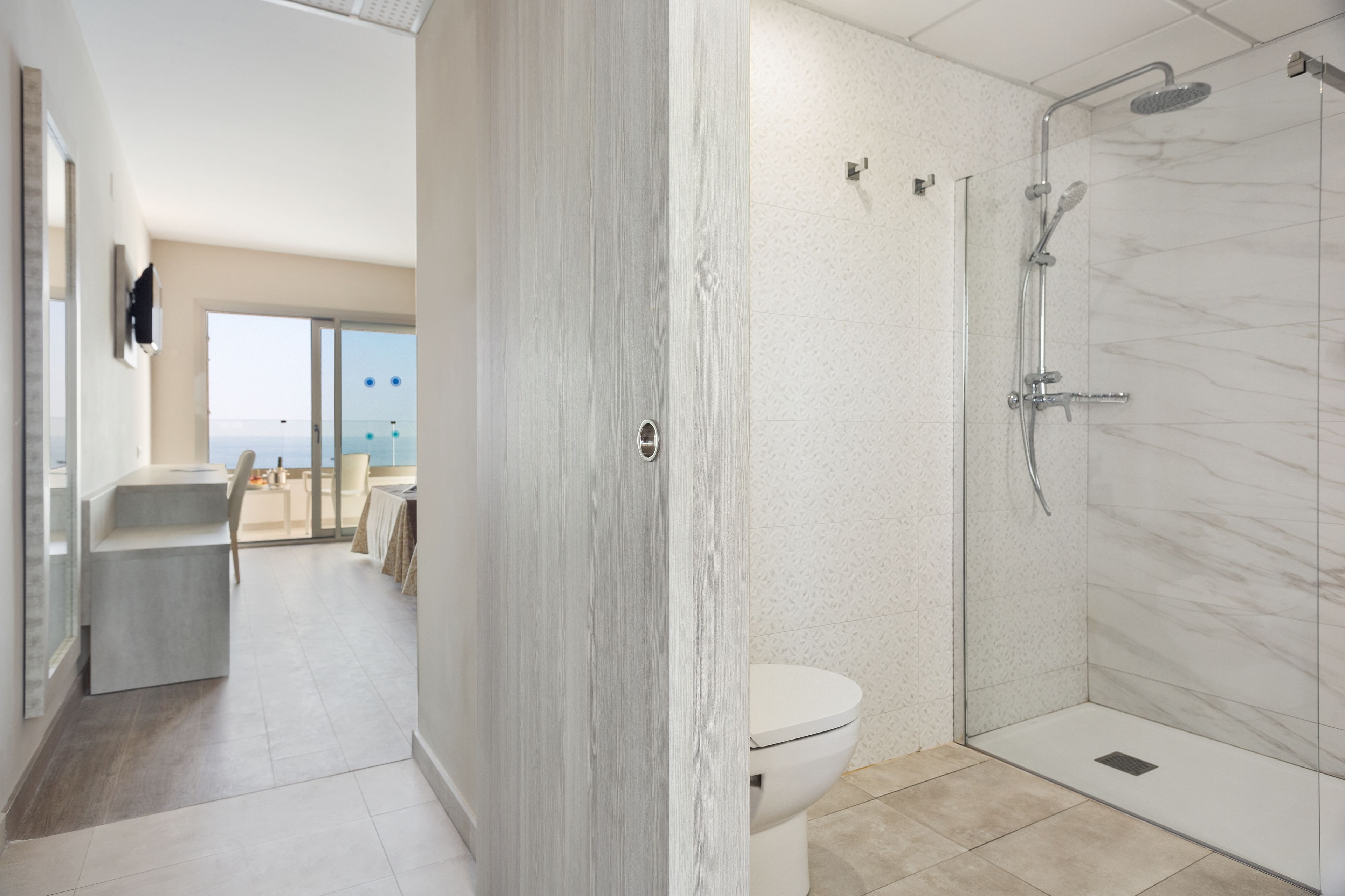 A modern bathroom with a glass shower enclosure, a toilet, and a sink.