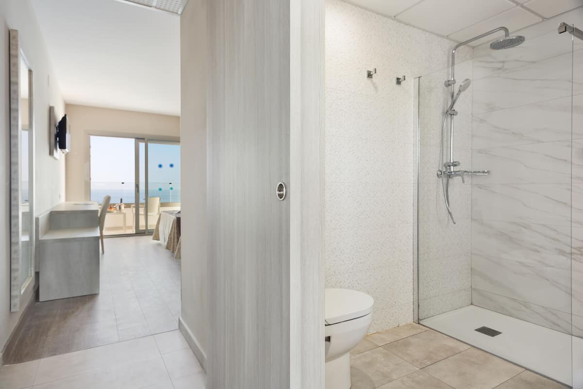 Ein modernes Badezimmer mit Glasdusche, Toilette und Waschbecken.