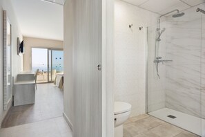 A modern bathroom with a glass shower enclosure, a toilet, and a sink. - Hotel Best Negresco (Salou)