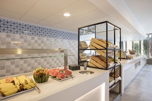 A buffet area with a variety of food items, including fruits and a watermelon centerpiece. - Hotel Best Negresco (Salou)