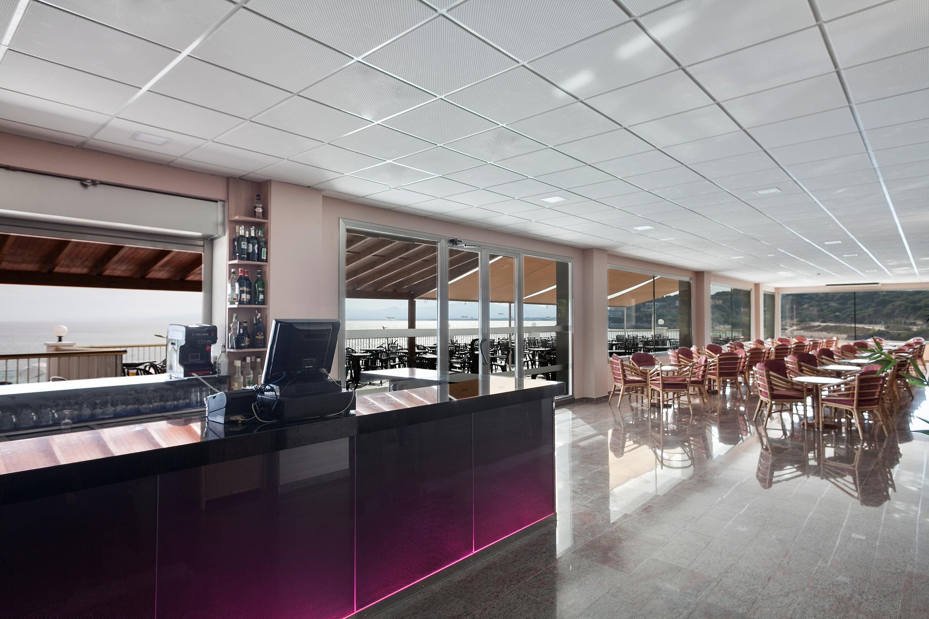 Een moderne bar met een toog, zitplaatsen en grote ramen met uitzicht.