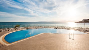 Une piscine avec vue sur la mer et les montagnes en arrière-plan.
