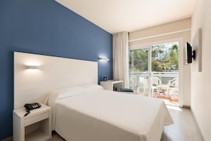 A hotel room with a bed, a desk with a phone, a TV mounted on the wall, and a balcony with chairs and a table. - Hotel Best Oasis Park (Salou)