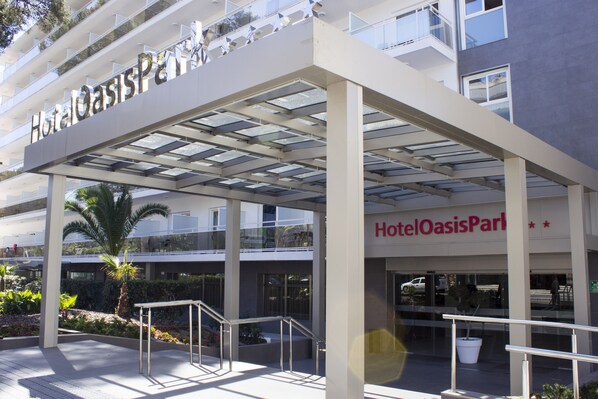 Hotel Oasis Park's entrance with a covered walkway, palm trees, and a modern architectural design. - Hotel Best Oasis Park (Salou)