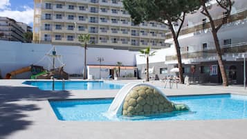 Una piscina techada, una piscina al aire libre, sombrillas