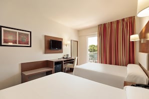 A hotel room with two beds, a desk with a television, a chair, a small table with a kettle, and a window with curtains. - Hotel Best Oasis Park (Salou)