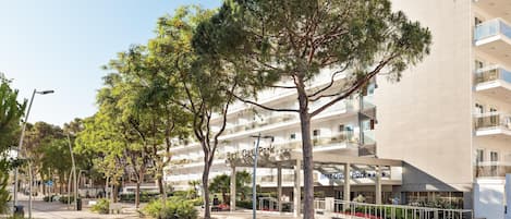 A multi-story hotel with outdoor seating and a clear sky.