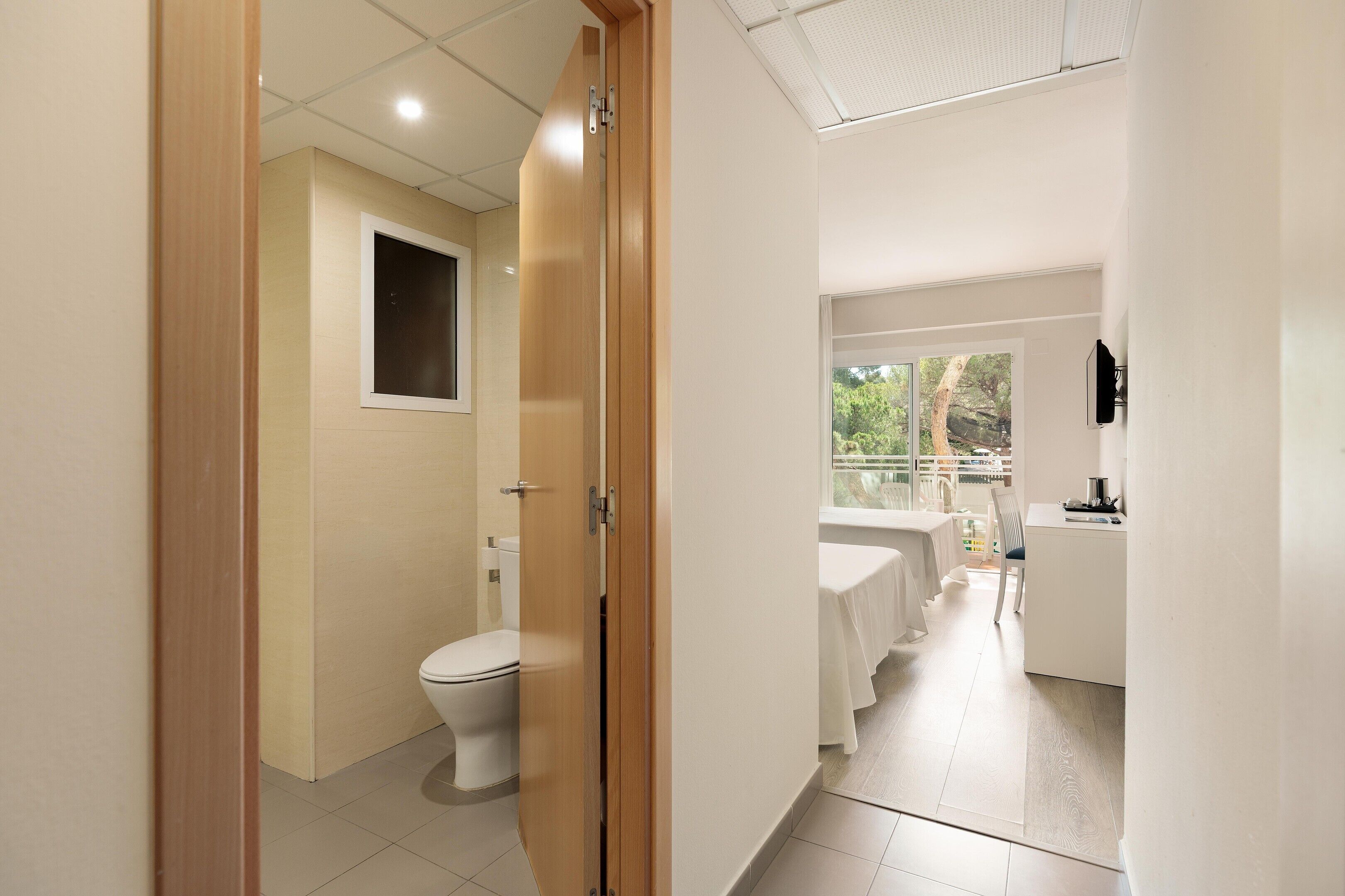 Un baño de hotel con inodoro, lavabo y zona de ducha.