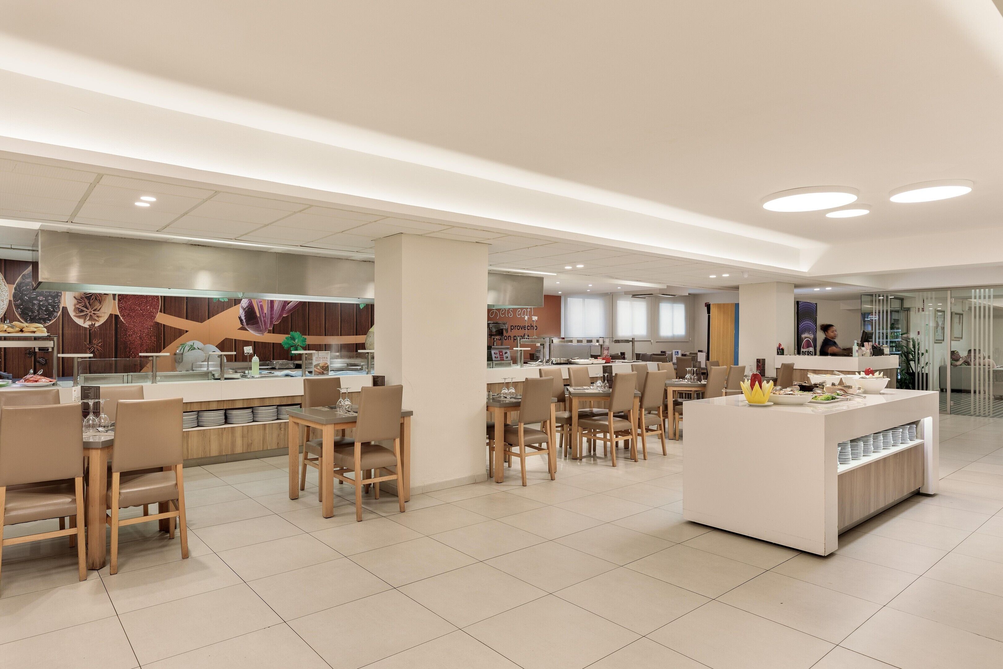 Un restaurante moderno con barra central, diversas opciones de asientos y un diseño limpio y contemporáneo.
