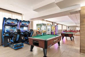 Un'area ricreativa con tavoli da biliardo e giochi arcade.