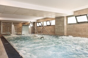 A large indoor swimming pool with a slide, multiple windows, and a high ceiling. - Hotel Best Oasis Park (Salou)
