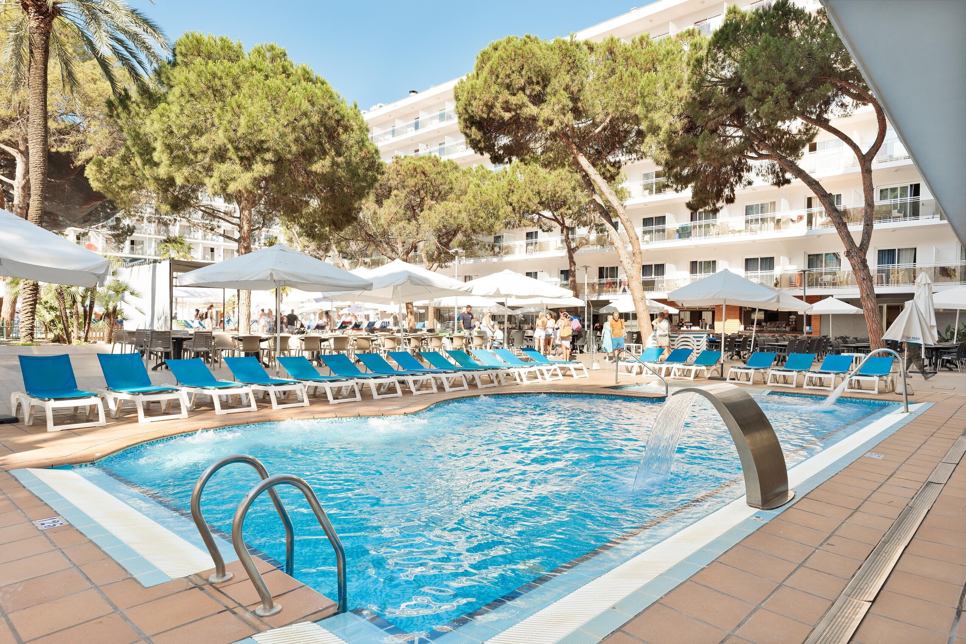 Una piscina cubierta, una piscina al aire libre, sombrillas, tumbonas