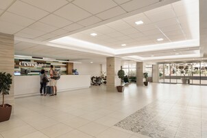 Un'ampia hall con reception, area relax e vista esterna.