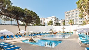 A pool area with multiple lounge chairs and umbrellas, a water slide, and a stone structure. - Hotel Best Oasis Park (Salou)