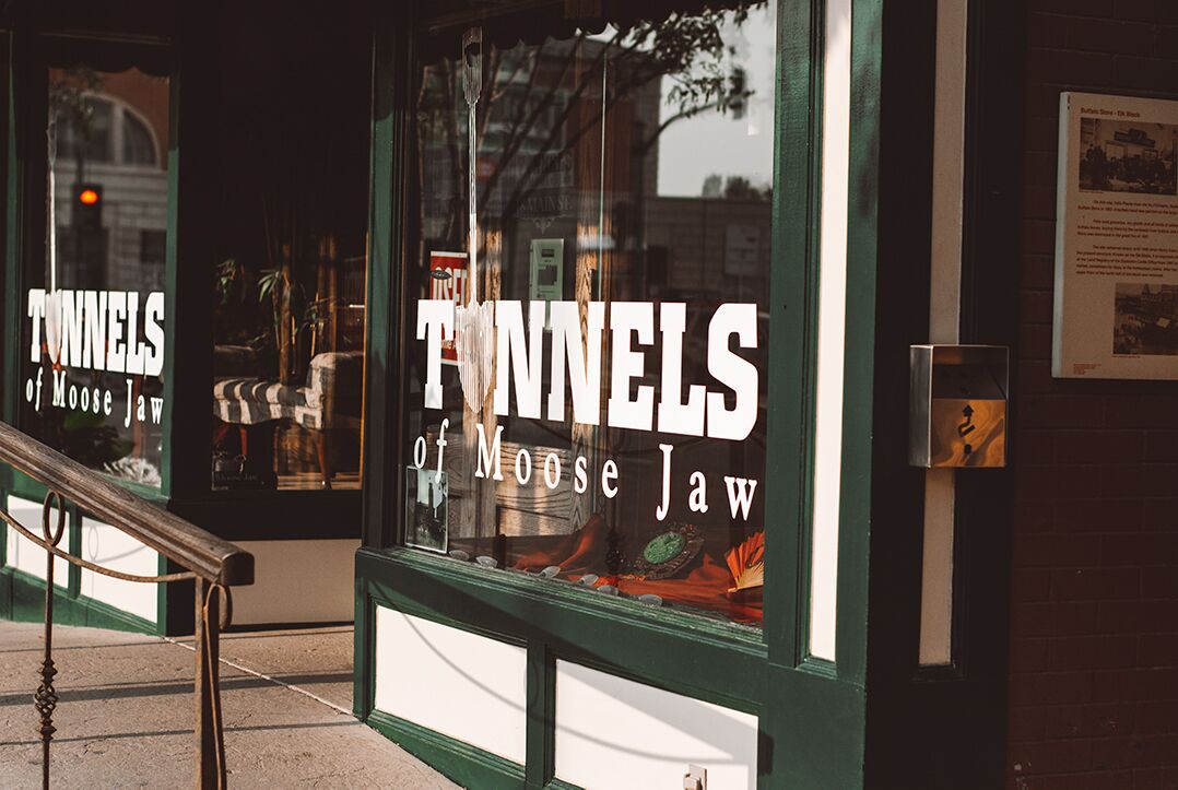 A storefront with large windows displaying 'TUNNELS of Moose Jaw' signage.