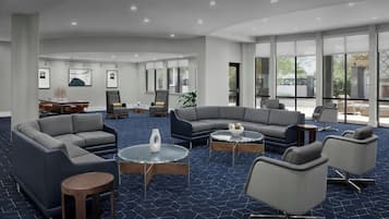 Un espace de détente moderne avec des canapés, des fauteuils et des tables rondes.