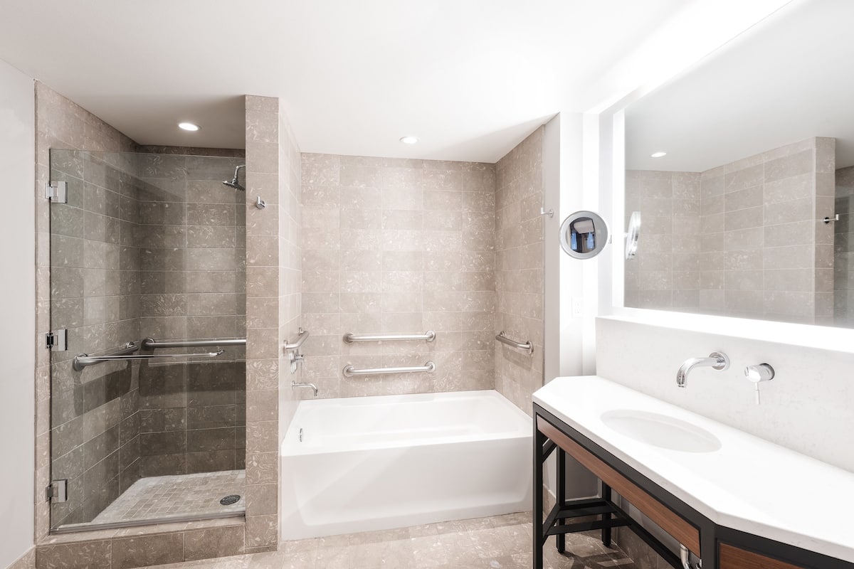 Een bad/douchecombinatie, designer toiletartikelen, een haardroger