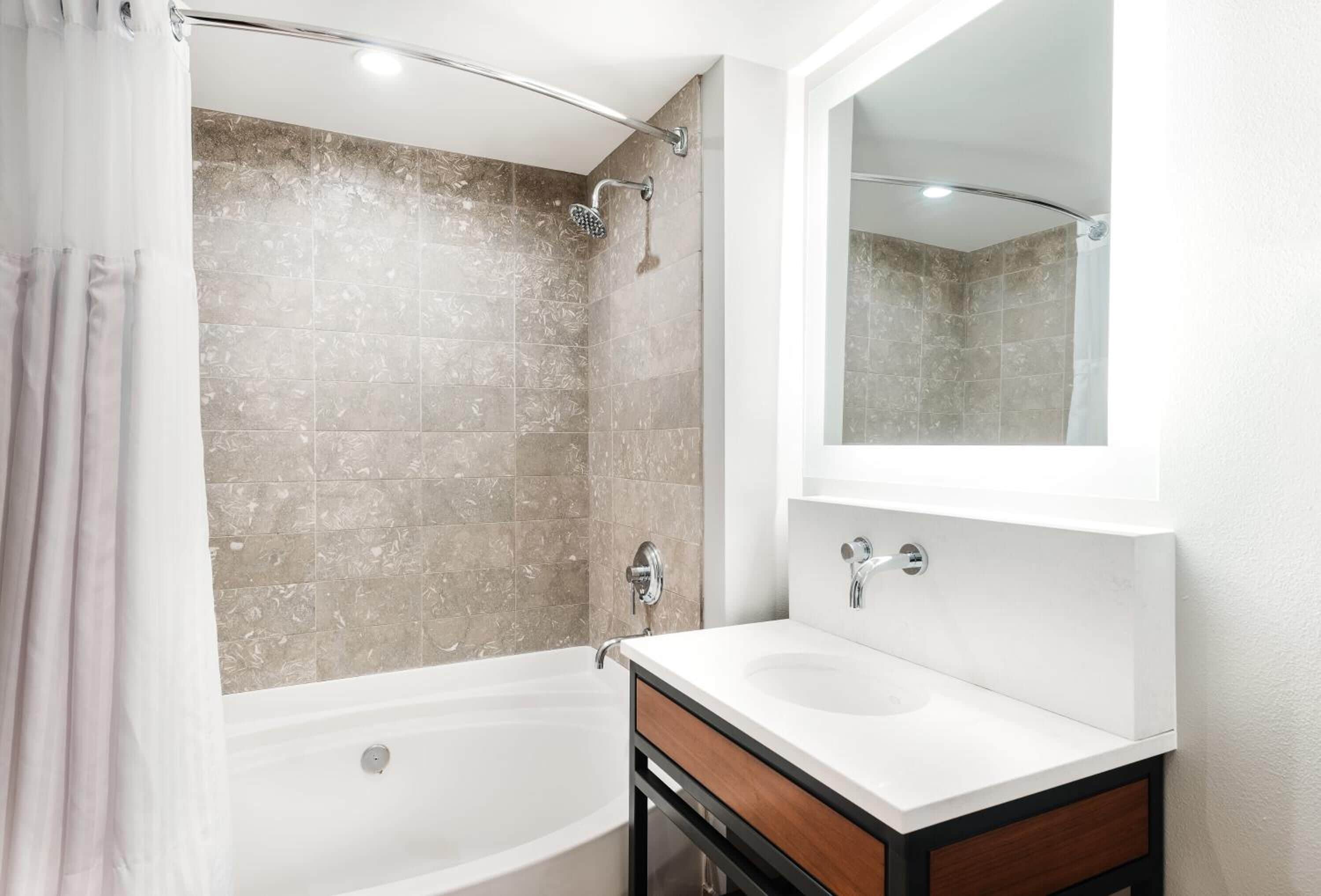 A bathroom with a bathtub, a shower, and a sink.