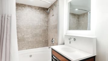 A bathroom with a bathtub, a shower, and a sink.