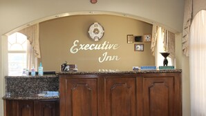 Une cuisine dotée d’un plan de travail en granit, de meubles en bois et d’une horloge murale.