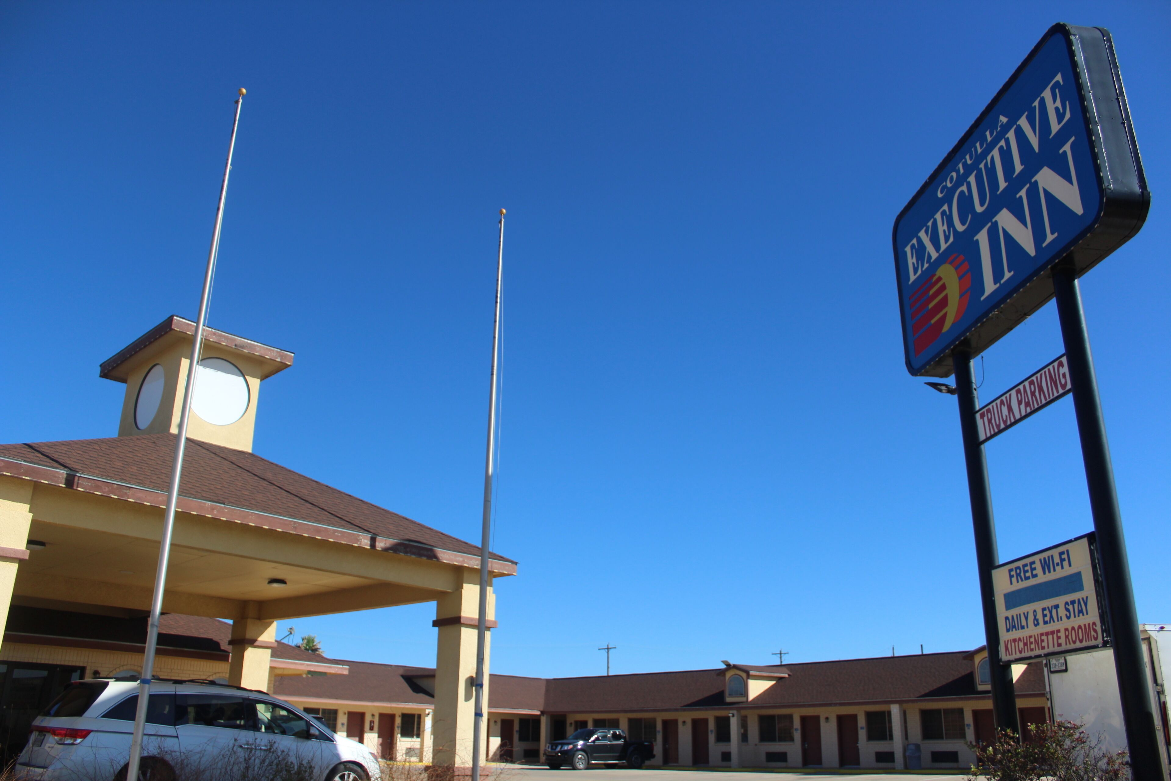 A motel with a sign reading "Executive Inn" and a "Free Wi-Fi" sign.