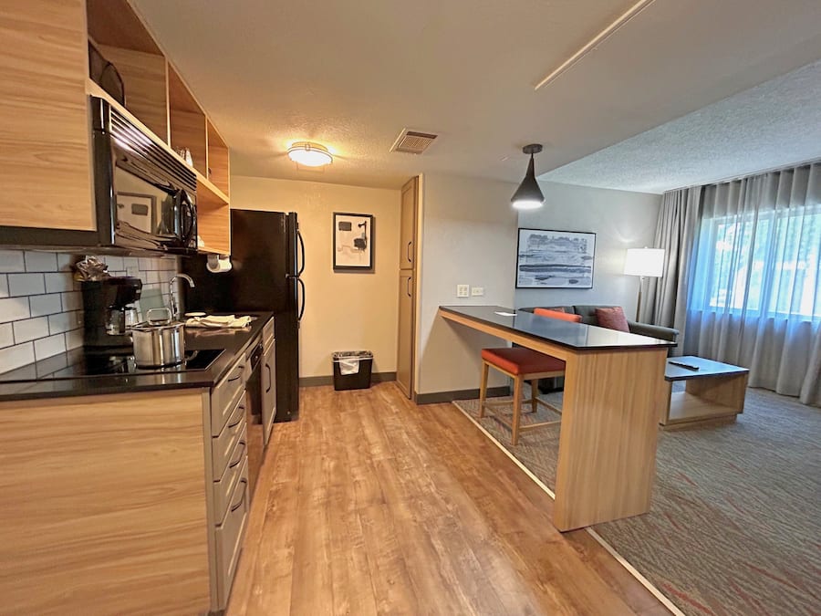 Habitació d'hotel senzilla amb cuineta, zona de menjador i espai de seients.