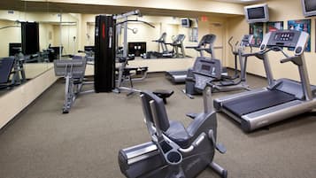 A gym with various exercise equipment including treadmills, elliptical machines, and weight machines.