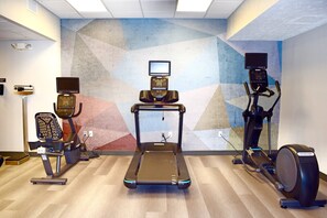 Une salle de sport équipée de tapis de course, de vélos elliptiques et d’un vélo d’appartement, le tout doté d’écrans numériques et de moniteurs de fréquence cardiaque.