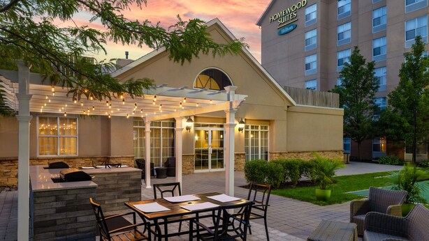 Eine Hotelterrasse mit Außenbereich, einer Bar und einem Pool.