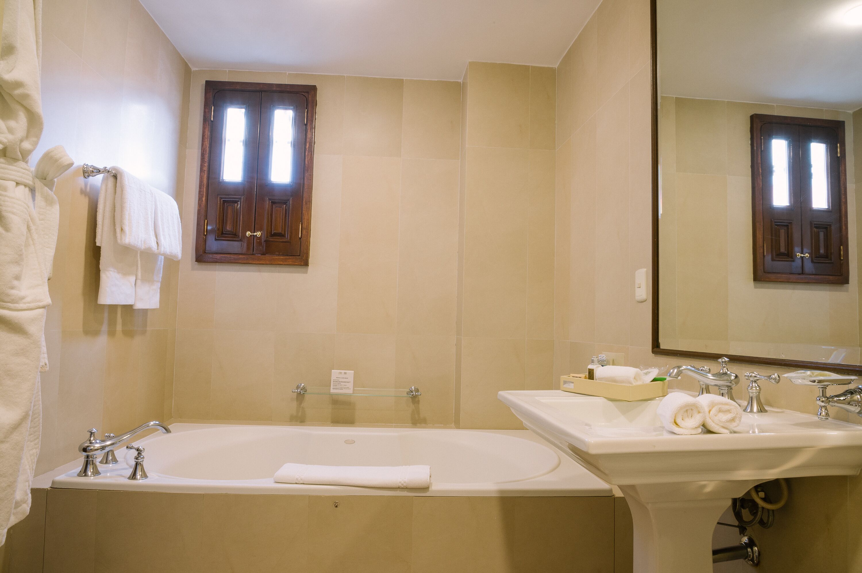 A bathroom with a bathtub, a sink, and a mirror.