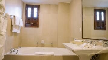 A bathroom with a bathtub, a sink, and a mirror.