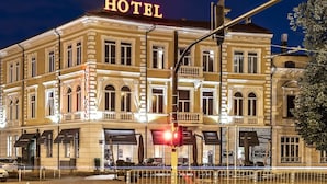 Un edificio histórico de hotel con un llamativo letrero 'HOTEL', varios balcones y un estilo arquitectónico clásico.