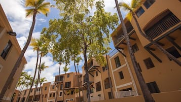 Un edificio de varios pisos con balcones y palmeras.