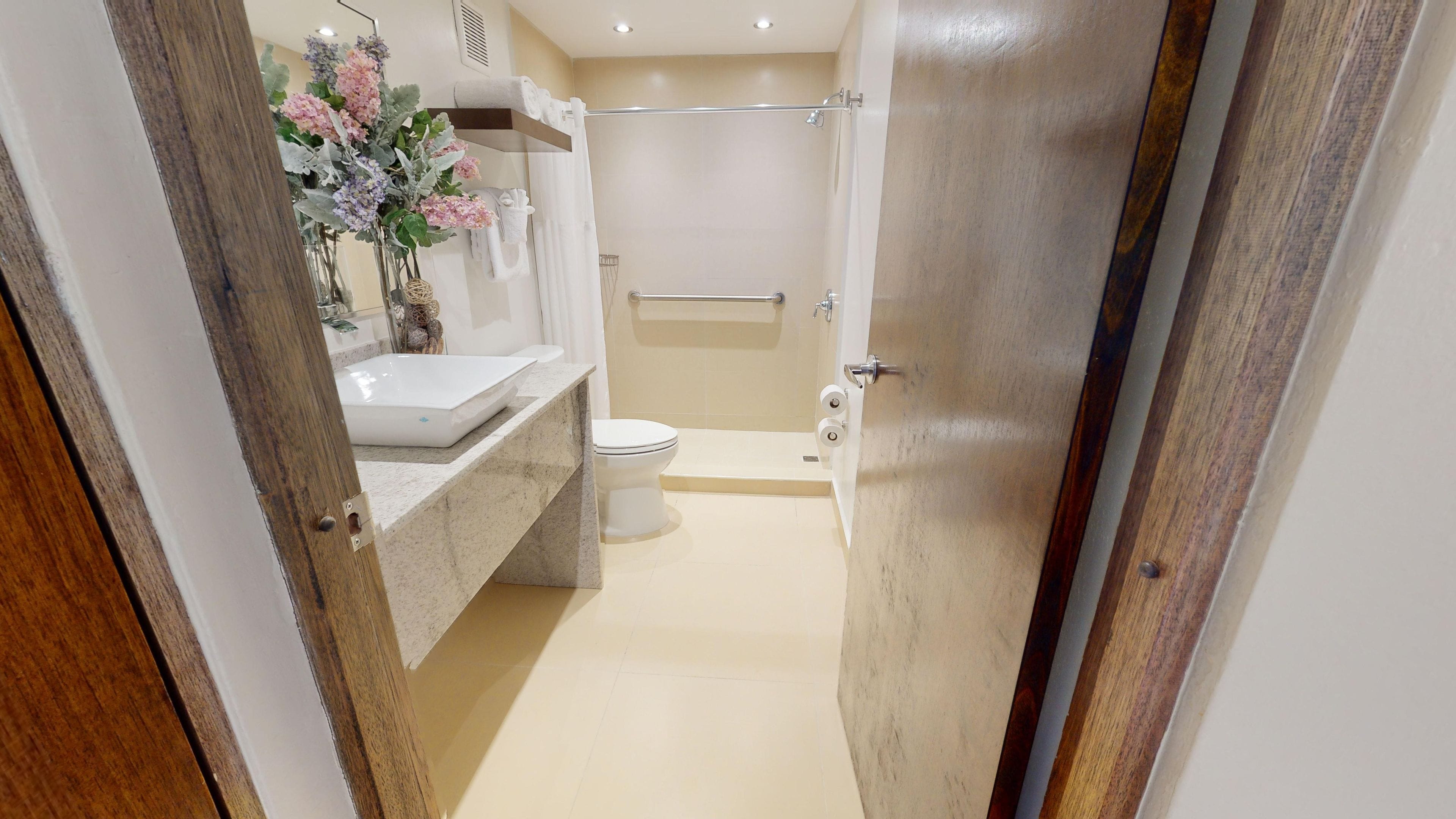 Un baño con inodoro, lavamanos y zona de ducha.