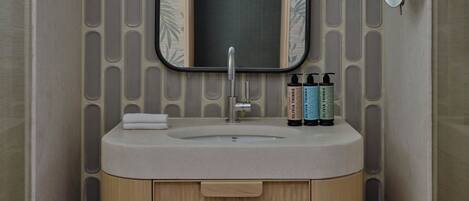 Un bagno con lavandino, specchio e articoli da toilette.
