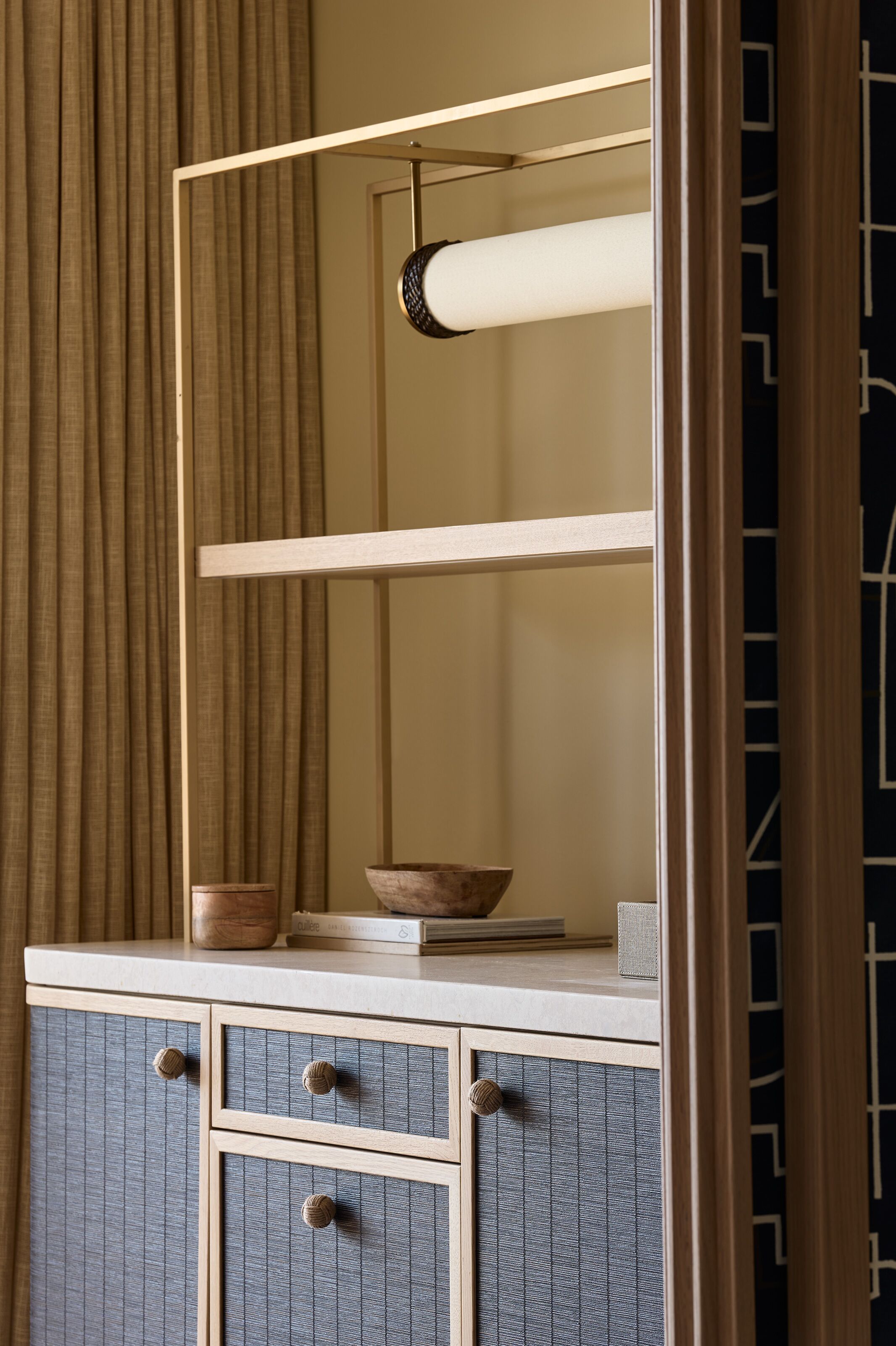 Una habitación con un armario de madera, un espejo y una lámpara colgante.